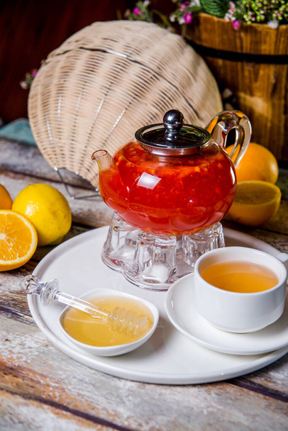 czerwona herbata jagodowa w przezroczystym szklanym czajniku z filiżanką herbaty. - Zdjęcie, obraz