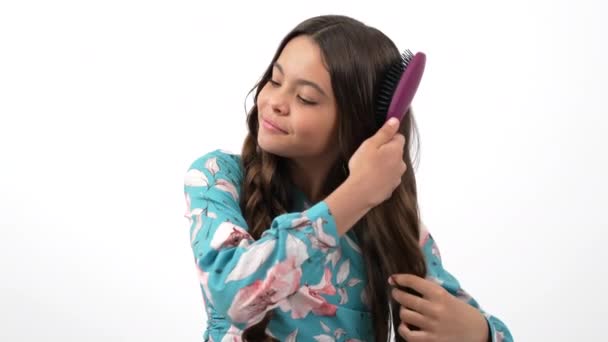 zdravé hladké vlasy usměvavé dítě kartáčování s hřebenem ukazující palec nahoru, péče o vlasy - Záběry, video