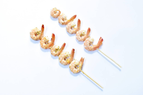  baked shrimp with butter and salt stabbing wooden stick on white background - Photo, Image