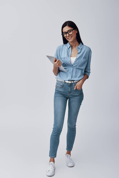 Full length of attractive young woman in eyewear carrying digital tablet - Fotoğraf, Görsel