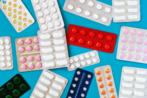 Different pills, tablets, capsule medicines blister packs, on blue background. Top view. Health care concept - Foto, Imagem