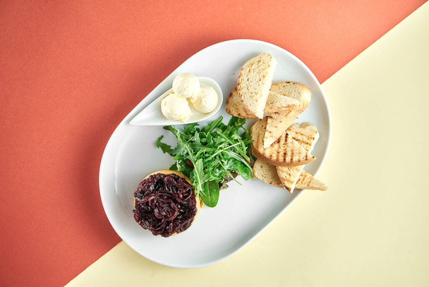 Turkey liver pate with onion confit, curtons in a white plate on bright colored backgrounds - Foto, imagen