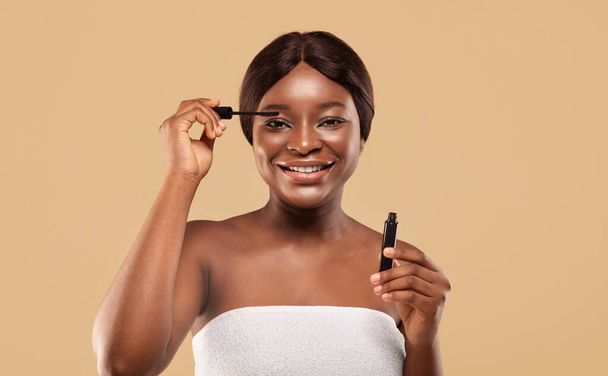 Portrait Of Happy Attractive Black Woman Applying Mascara On Eyelashes - Photo, image