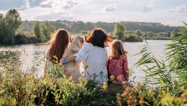 Family with golden retriever dog outdoors - Fotografie, Obrázek