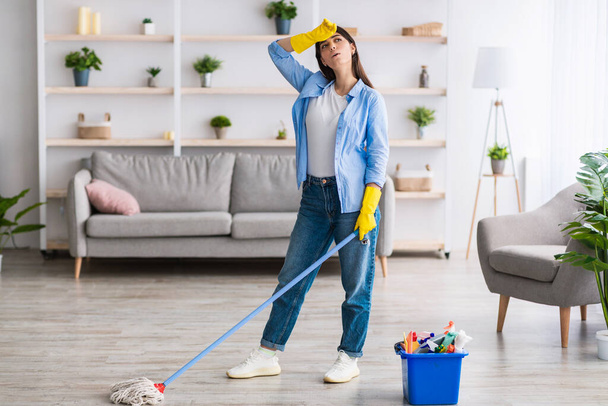 Zmęczona kobieta sprzątająca podłogę mopem smyczkowym - Zdjęcie, obraz