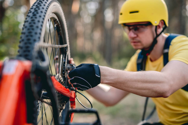 Cyclist checking chainwheel defect - Valokuva, kuva