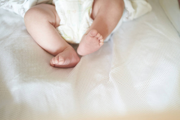 Baby legs on white sheet, newborn baby 1 month, care and love - Foto, Imagem