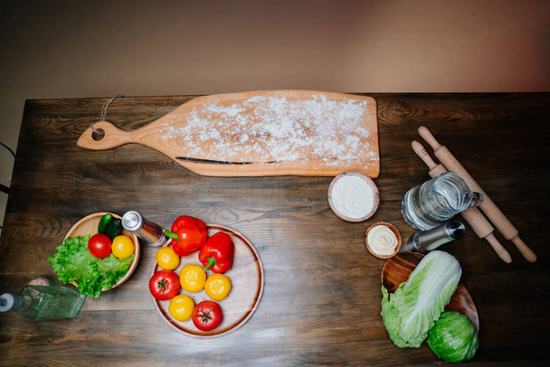 cutting board covered with flour and vegetables for cooking dishes from dough.  - Fotografie, Obrázek