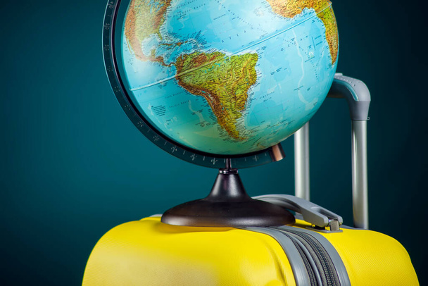 Globe on luggage. Travel and holiday concept. Studio shot - Fotografie, Obrázek