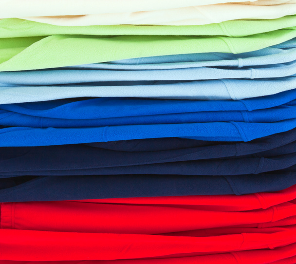 Многоцветные спортивные рубашки в магазине
 - Фото, изображение