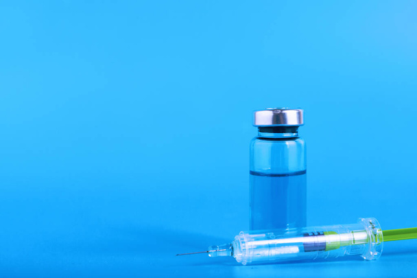 Medical ampoules and syringe on a blue background. Copy space. Selective focus - Fotó, kép