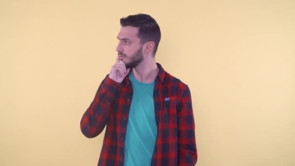 Un hombre reflexivo arañándose la barbilla pensando y mirando a un lado - Metraje, vídeo