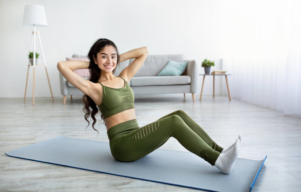 Mulher indiana atlética fazendo exercícios no tapete de ioga, fortalecendo seus músculos abdominais em casa. Desportos domésticos - Foto, Imagem