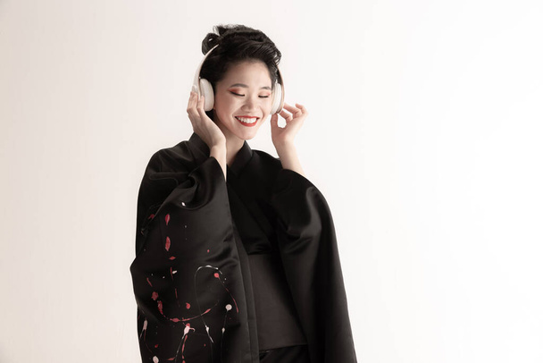 Ritratto di giovane bella giapponese, donna in costume nazionale kimono posa isolata su sfondo bianco studio. - Foto, immagini