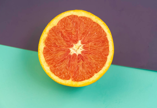 Half of Grapefruit with fresh pulp put on colorful background,blurry light around - Fotó, kép