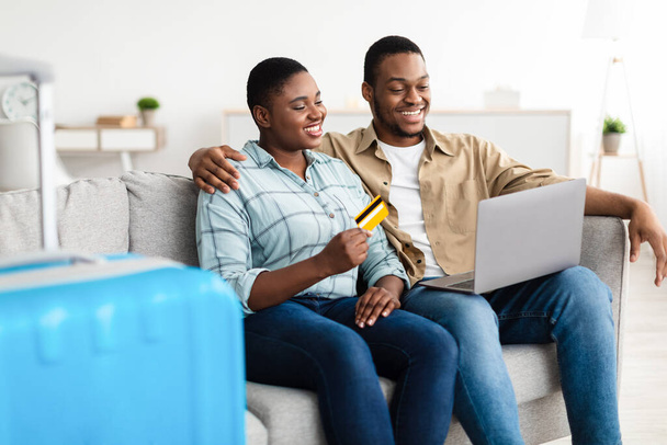 volo africano coppia prenotazione con computer portatile e carta di credito coperta - Foto, immagini