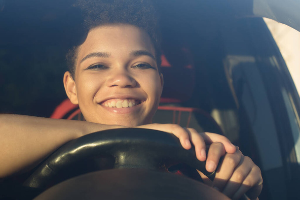 happy and beautiful african american woman with short hair in a car, lifestyle. - Photo, Image