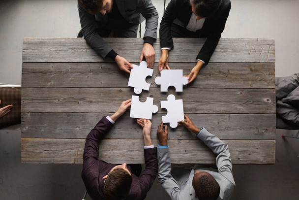 Business teamwork with puzzle finishing project cooperation unity concept - Фото, изображение