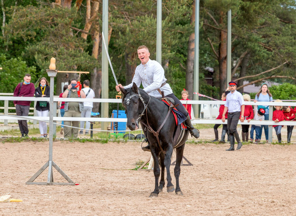 Kuban Cossack on horse performing tricks on the on open-air. XXII International Equestrian Exhibition Hipposphere. Saint-Petersburg - June 13, 2021. - Foto, Bild