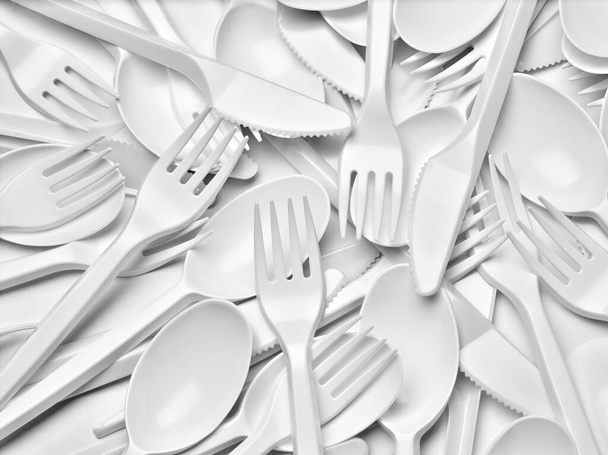 close-up van plastic bestek lepel, vork, mes op witte achtergrond - Foto, afbeelding