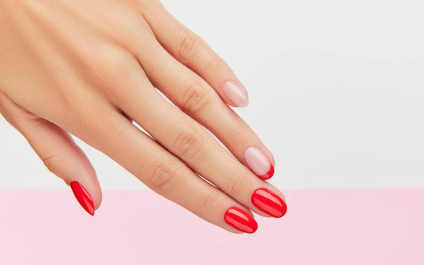 Womans hand with fashionable red manicure over white and pink background - Photo, Image