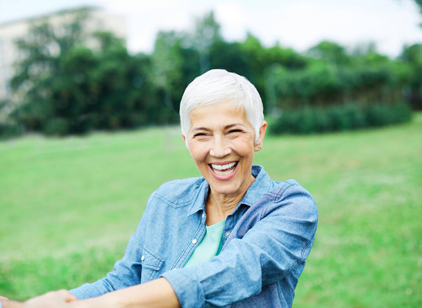 portré boldog mosolygós idős nő szabadban - Fotó, kép