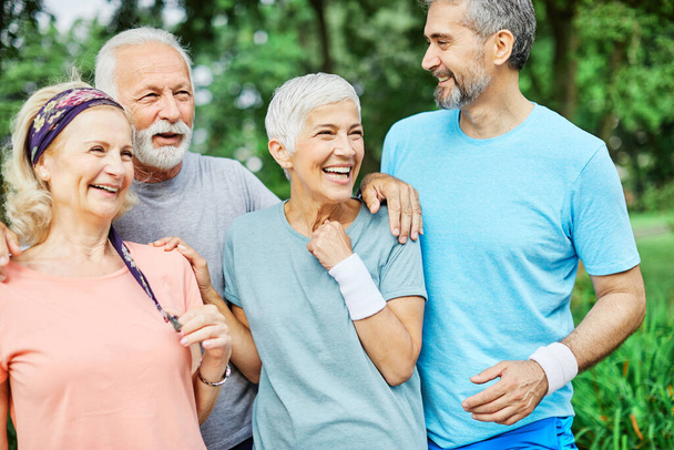 Sonriendo personas mayores activas posando juntas en el parque - Foto, Imagen