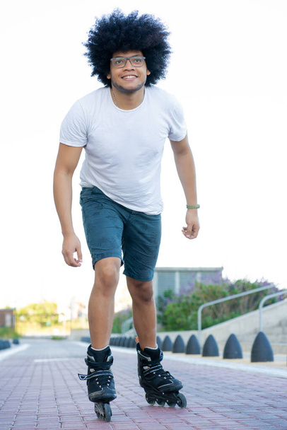 Latin man rollerskating outdoors. - Fotó, kép