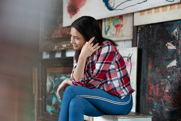 young beautiful woman posing in the studio, sitting in a plaid shirt - Fotografie, Obrázek