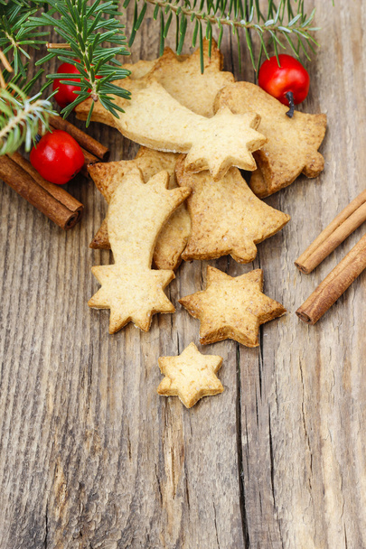 Christmas cookies on wooden table under fir branch. - Foto, afbeelding