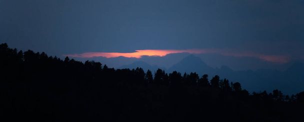 Panorámás hegyi rétegek napnyugtakor vagy napkeltekor. Tájkép sötét ködös sziluettje alpesi hegyek és fenyőerdők Pireneusokban. - Fotó, kép