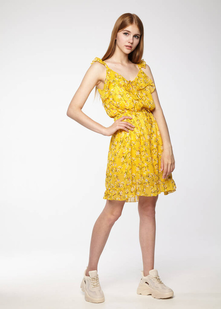beautiful girl in a yellow summer dress on a white background - Фото, зображення