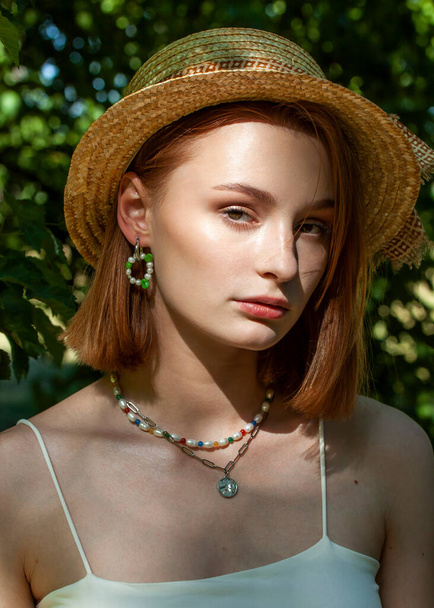 portrait of a beautiful redhead girl in nature in a hat - Foto, Imagen
