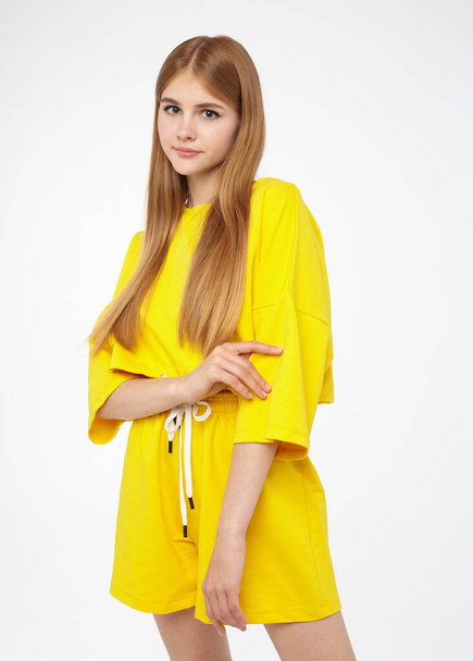 portrait of a beautiful girl in a yellow summer suit on a white background - Fotoğraf, Görsel