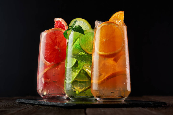 Sekoita kolme jäätä virkistävää juomaa appelsiinin, limetin ja greipin kanssa Kylmä virkistävä cocktail terveellinen juoma vieroitukseen. Kesä virkistävä juoma. Myrkytykseen käytettävä kylmä vesi  - Valokuva, kuva