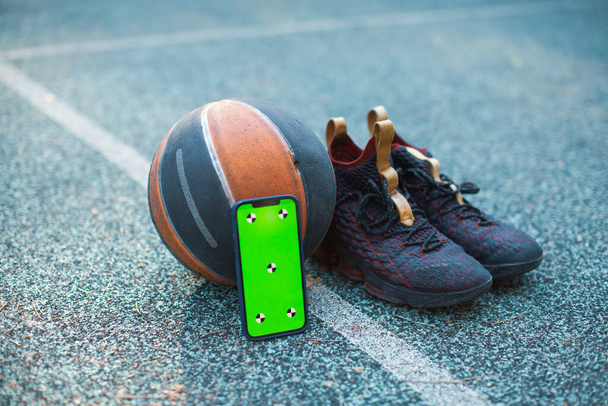 Green screen phone mock up with tracking markers, basketball ball, sports shoes for training. Chroma key, copy space - Фото, зображення