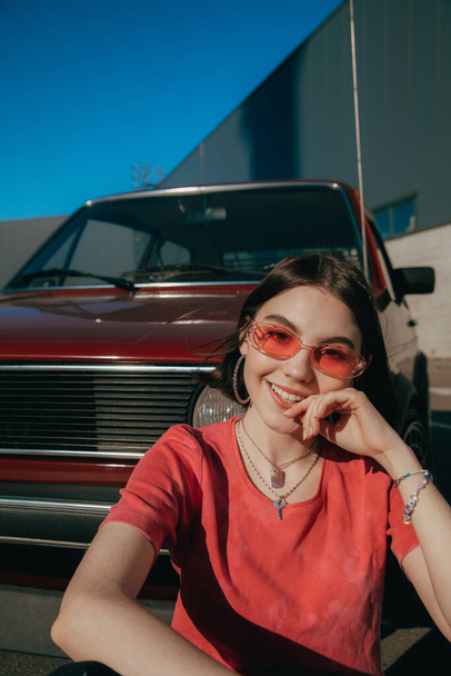 Teenager wearing sunglasses smiling widely to the camera while spending summer - Фото, зображення
