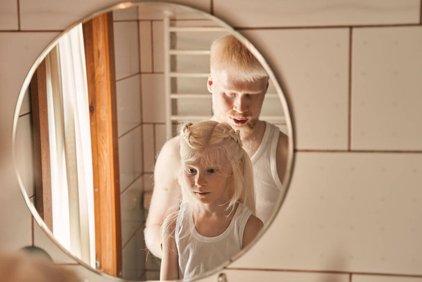 Man helping to preparing hairstyle for his little blonde daughter at home - Foto, Imagem