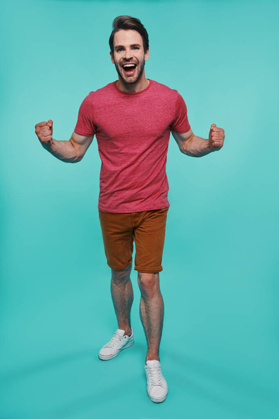 Full length of excited young man in casual clothing looking at camera and gesturing - Fotoğraf, Görsel