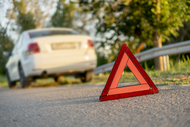 a red triangle sign on the road as the symbol of the car crash accident on highway - Zdjęcie, obraz