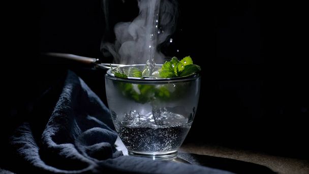 Brew the currant leaves in boiling water through a sieve into a glass - Zdjęcie, obraz