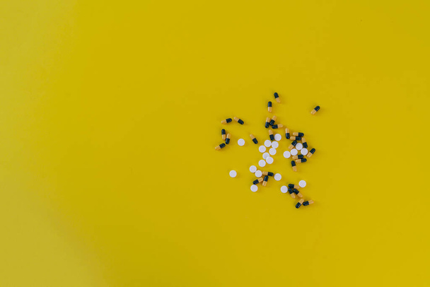 ένα μικρό μάτσο διαφορετικά χάπια φάρμακο επίπεδη θέσει στο πολύχρωμο υπόβαθρο, μινιμαλισμός έννοια helthcare - Φωτογραφία, εικόνα