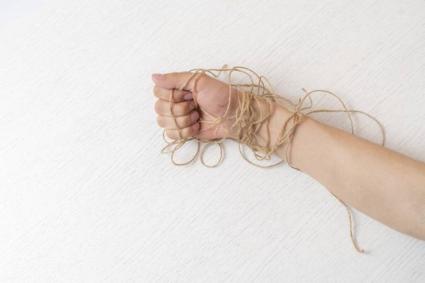 a persons hand in the rope tighten against the colorful background, symbol of personal rights and laws - Foto, imagen