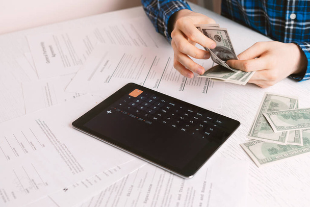 підрахунок готівкових грошей, людина обчислює особисті доходи та заощадження за столом
 - Фото, зображення