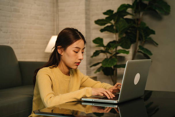 Businesswoman working on laptop at night - Foto, afbeelding