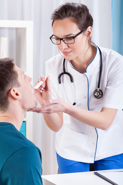 Doctor examining throat of the patient - Foto, Imagen