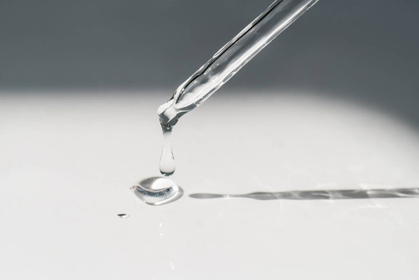 A drop of cosmetic oil falls from the pipette - Photo, image