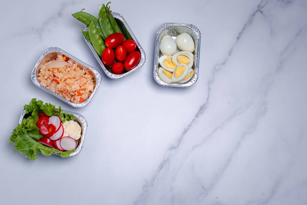 Tolga il cibo sano in scatole di lamina di metallo su tavolo di marmo. Copia spazio - Foto, immagini