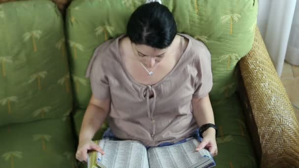 bovenaanzicht van een gelukkige vrouw lezen van een boek - Video