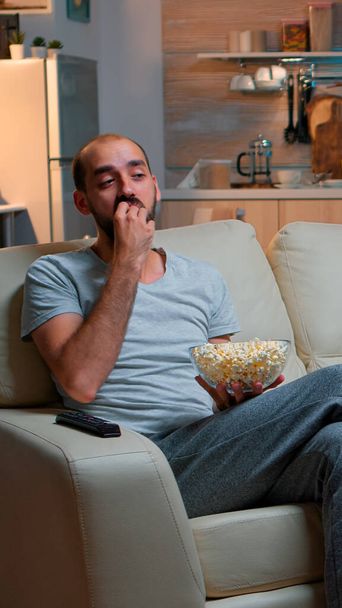 Mann isst Popcorn und schaut fern - Foto, Bild